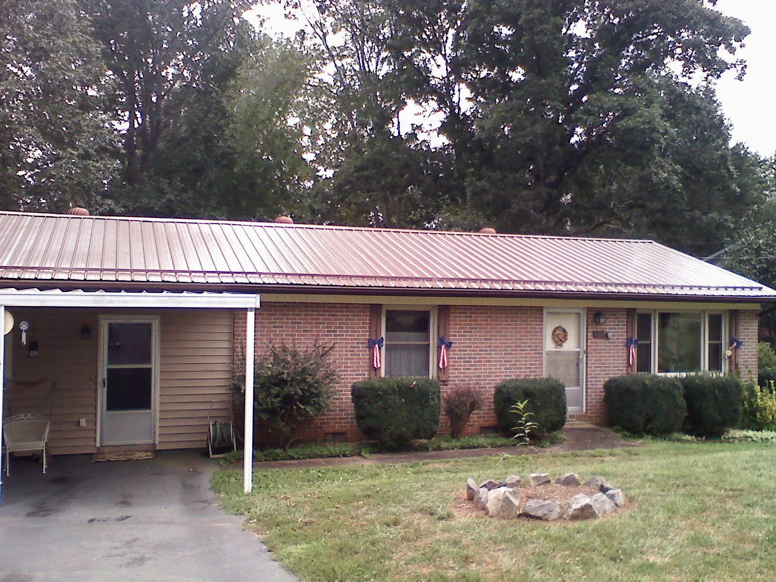 Bronze metal roof and carport on a brick ranch home — Roof Repair work by our crew in Cadogan